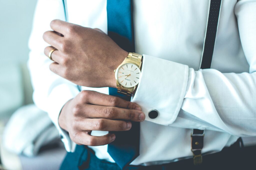 Elegancki mężczyzna w białej koszuli ze złotym zegarkiem
